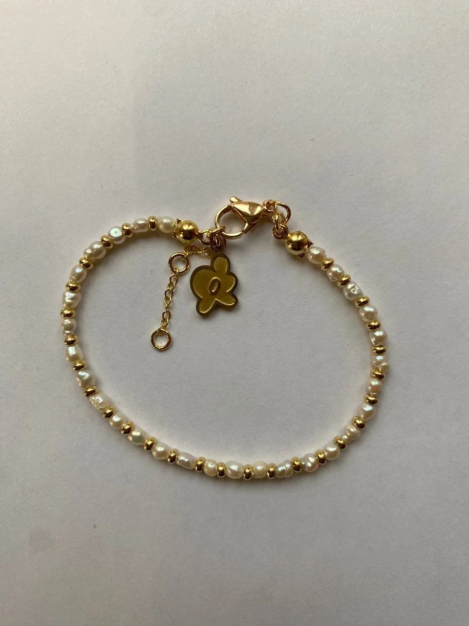 The same bracelet on a white table, shot on a phone