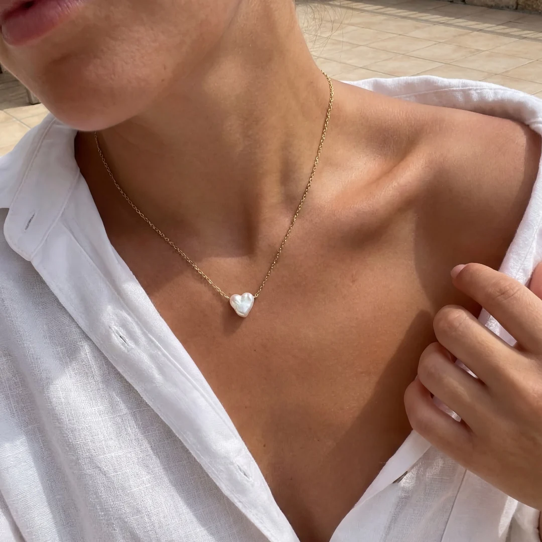 Mobile shoot — pearl pendant on a model in golden hour light