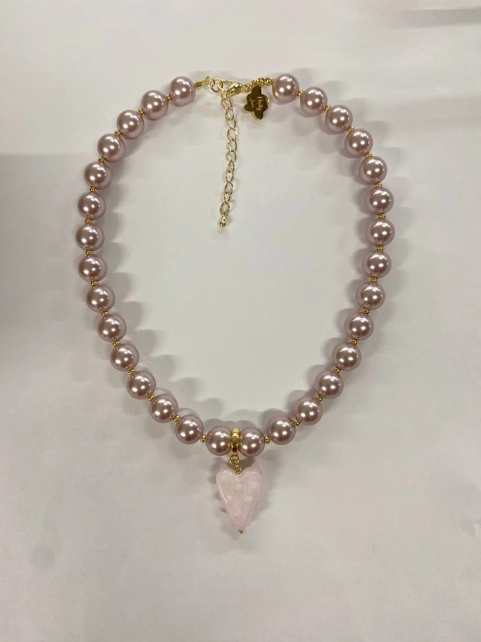 The same pink pearl necklace, laid flat on a desk